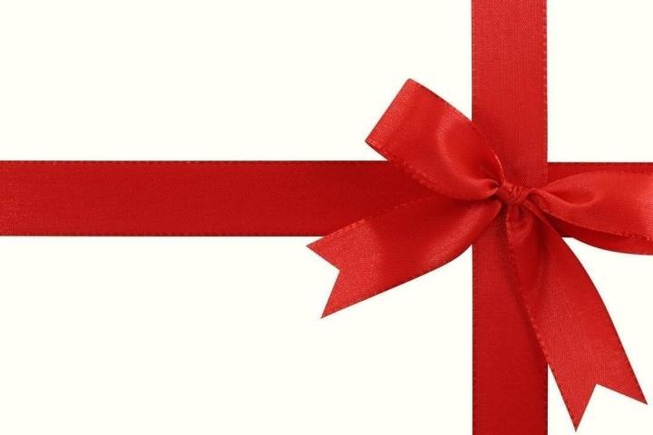 Red ribbon tied in a bow on a white background.